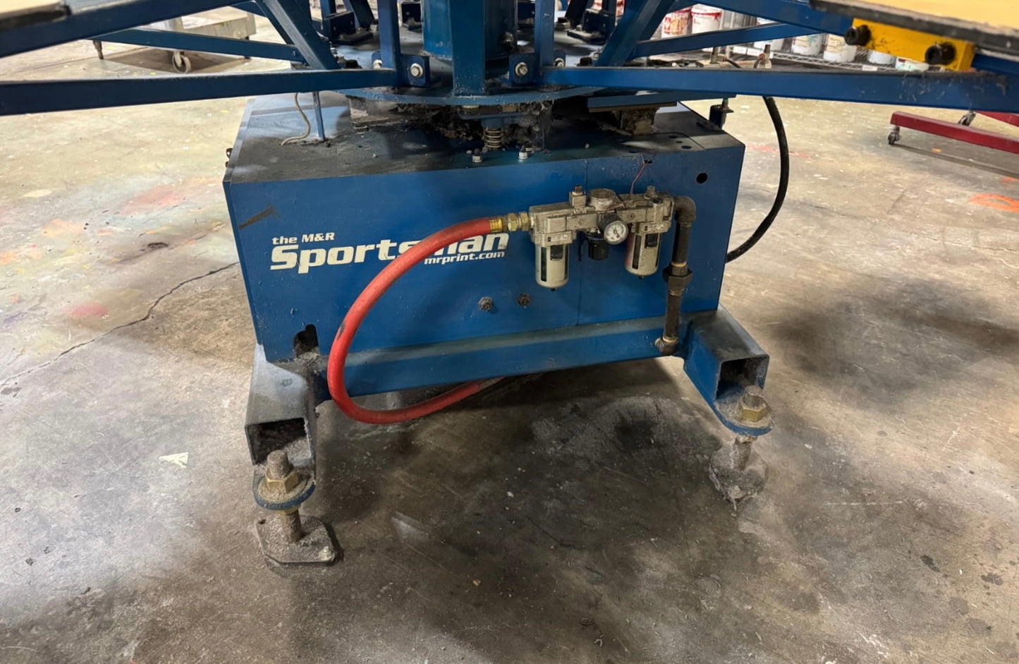 Blue machine with 'Sportsman' branding on a concrete floor