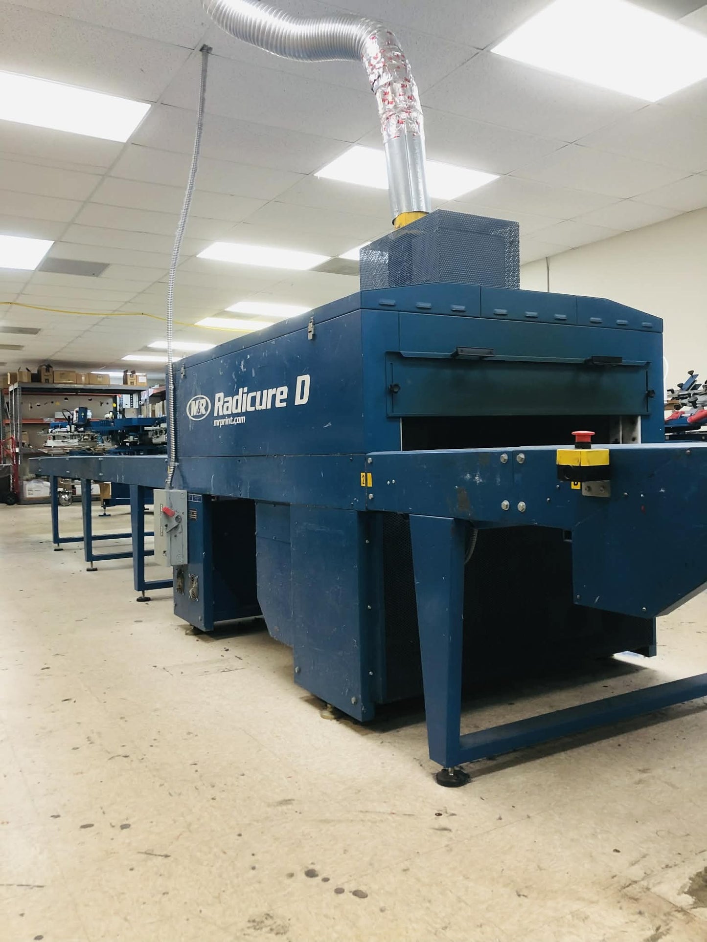 Large blue machine labeled 'Radicure D' in a warehouse setting