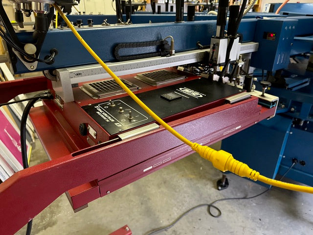 m&r machine with a red flash and yellow cable on a concrete floor