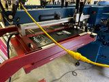 m&r machine with a red flash and yellow cable on a concrete floor